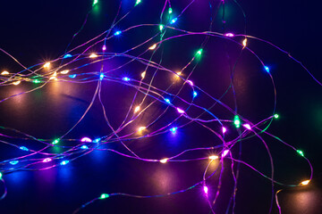 Abstract Christmas lights on black background. Glowing light bulb garland,