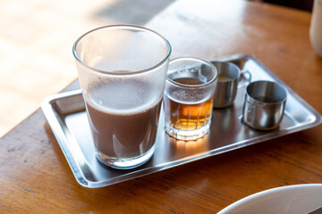 A set of hot drinks and condiments sits on the table.