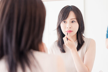 家でメイクをする若い女性