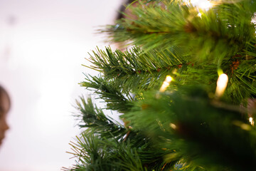 Fototapeta na wymiar details of christmas tree ornaments illuminated with golden lights.