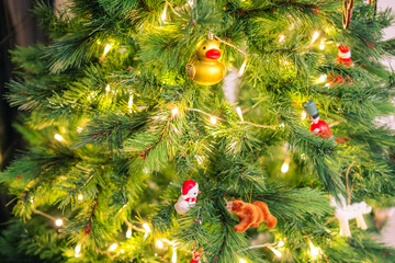 details of christmas tree ornaments illuminated with golden lights.