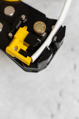 The use of the stripper cutter tool to strip the end of the electrical wire