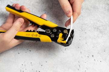 The use of the stripper cutter tool to strip the end of the electrical wire