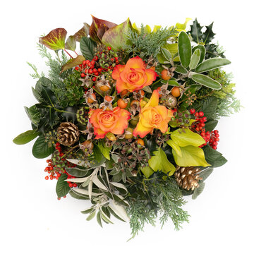 Winter festive floral arrangement. Flame colour roses, berries, greenery and leaves. On white background.