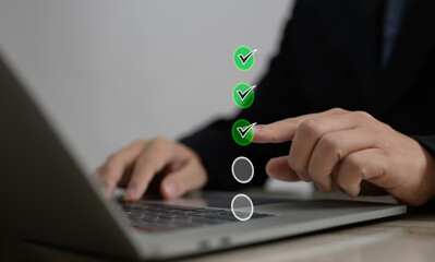 Performance checklist concept : businessman using stylus pen with laptop for questionnaire,...