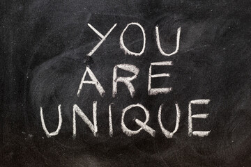 Fototapeta premium La frase, you are unique, escrita a mano con una tiza en la pizarra 