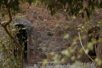 Ancient Arc Wall made up of old Brown Brick stone with bokeh shot of green plants