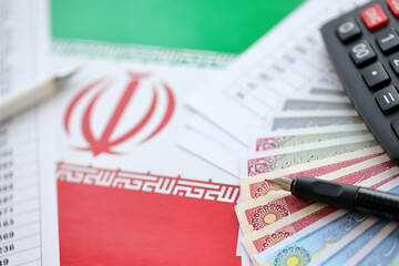 Iranian business calculations on table with iranian money and pen close up