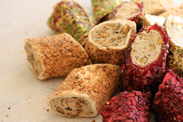 Many rolls of turkish delight with different flavors and fillings close up on table. Cutted Turk Lokumu bars