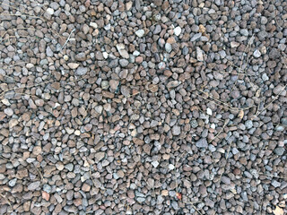 A close-up view of small brown pebbles and natural stones. Ideal for use as a graphic source or background image