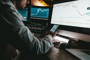 Close-up of male financial broker using technologies while analyzing stock market graphs and charts 