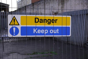 Danger Keep Out sign on metal security fence. Unsafe site with keep out sign  