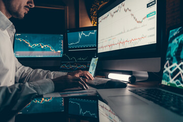 Close-up of financial broker working on computer while trading on stock market in night office