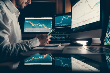 Close-up of male financial broker using technologies while trading on stock market at the office