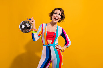 Photo of laughing young girl stylish makeup second hand shopping ad find glitter disco ball 90s theme isolated on yellow color background