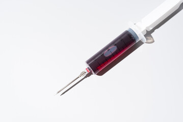 Jeringa llena de sangre para análisis sobre fondo blanco, Vista superior	