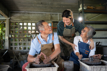 Portrait of a senior Asian couple doing activities together in the pottery workshop.