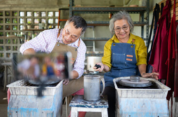 Asian retired couple with pottery making and clay painting activities in the pottery workshop with live broadcasting via social media channels