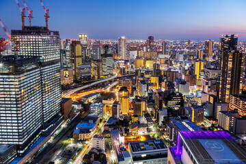 Osaka big city lights from above skyline with skyscraper at twilight in Japan - obrazy, fototapety, plakaty