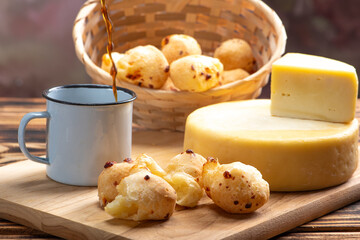 Cheese bread and cheese, a table with cheese bread and pieces of cheese and a cup of coffee on a rustic table, selective focus.