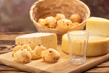 Cheese bread and cheese, a table with cheese bread and pieces of cheese and a glass of coffee on a rustic table, selective focus.