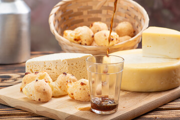 Cheese bread and cheese, a table with cheese bread and pieces of cheese and a glass of coffee on a rustic table, selective focus.