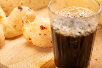 Cheese bread and cheese, a table with cheese bread and pieces of cheese and a glass of coffee on a rustic table, selective focus.