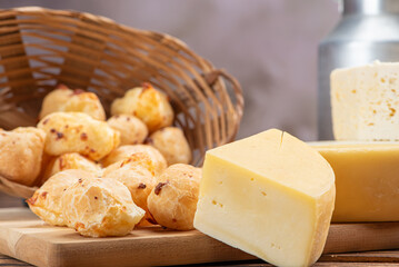 Cheese bread and cheese, a table with a basket of cheese bread and pieces of cheese on a rustic table, selective focus.