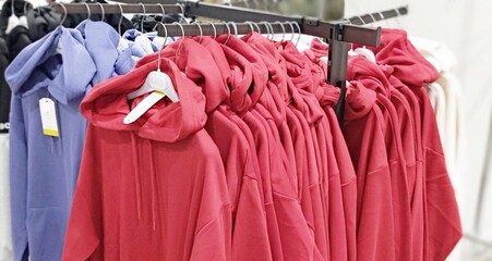 red and blue hoodies hanging on a hanger in a store
