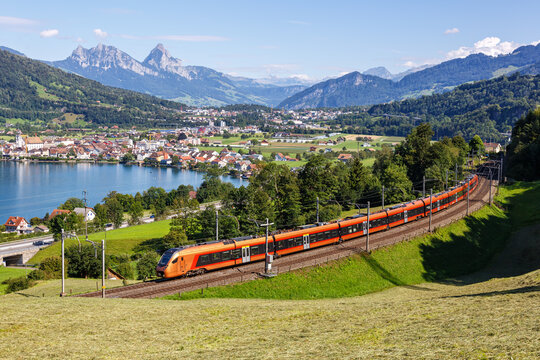 Passenger train type Stadler Flirt of S&uuml;dostbahn at Grosser Mythen mountain at Lake Zug in the Swiss Alps in Arth, Switzerland