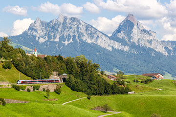 Passenger train type Stadler Flirt of Südostbahn at Grosser Mythen mountain in the Swiss Alps in...