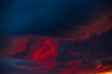 Beautiful sunset. Scarlet and black clouds in the summer sky before the rain