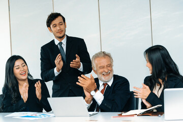 Senior caucasian manager working in office with assistance of young Asian business people and...