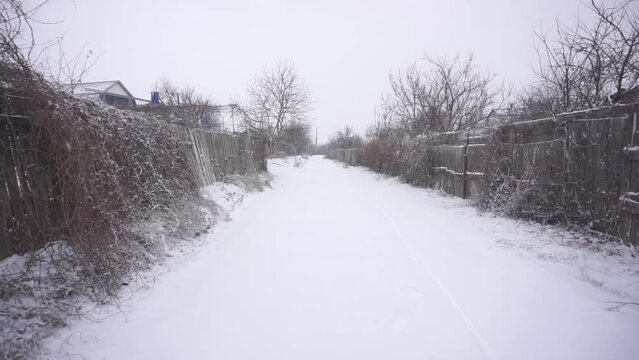 The road is covered with snow in the village