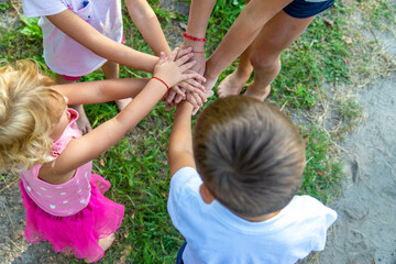 a group of children stand together in a circle and fold their hands, team spirit before the game.