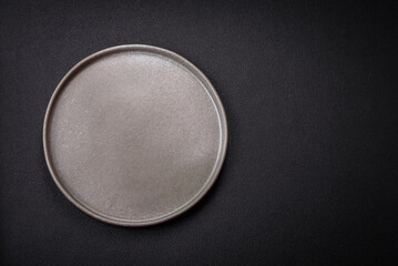 Bumpy empty ceramic plate on a textured concrete background
