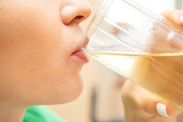 Closeup of woman drinking juice from glass - obrazy, fototapety, plakaty
