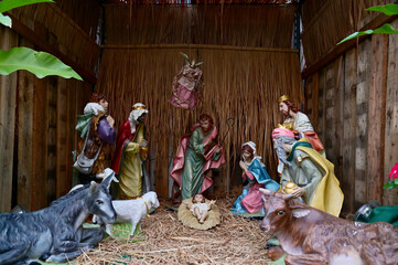 Fototapeta na wymiar Statuettes of Mary, Joseph and baby Jesus,The birthday of Jesus is a statuette of Maria with Joseph and newborn Jesus on the hay, A Christmas nativity scene.