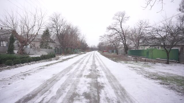 The road is covered with snow in the village