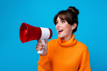 Photo of excited funky lady wear knitted pullover screaming bullhorn empty space isolated blue...