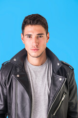 Obraz premium Young handsome man standing in studio shot, wearing black leather jacket and jeans