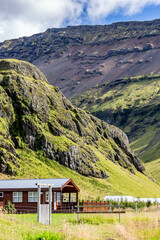 Southern Iceland, travel destination photograph, old house in the valley below the mountains