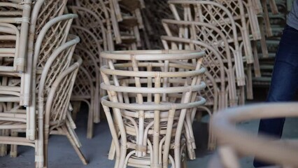 a worker stacking rattan products - Powered by Adobe