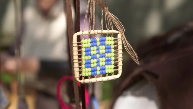 Static Close Up Shot of Decorative Pendant with Beads Gently Swings in the Wind