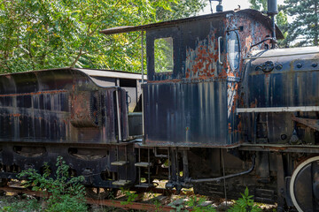 old rusty steam locomotive standing abandoned in the forest