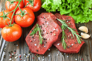 Raw beef steak with vegetables and spices