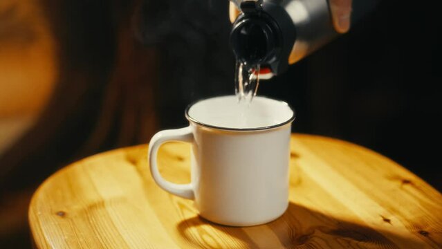 close-up of hot tea being poured into a tiny cup. Cinematic video. Ideal for those who love tea drinking.