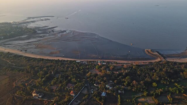 Cinematic aerial shot of a Mandwa beach near Alibuag, Maharashtra, India. Aerial view of boats and the green sea with the beautiful Ocean coast.