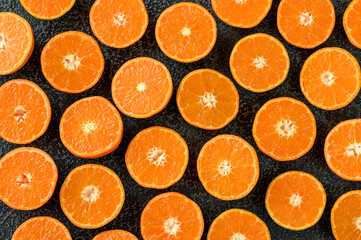 Fresh tangerines' slices on black background