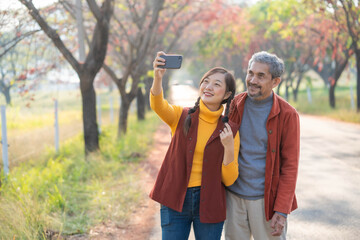 Happy family time. Father and daughter selfy on country road with maple tree during autumn season